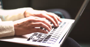 Mãos femininas digitando em notebook